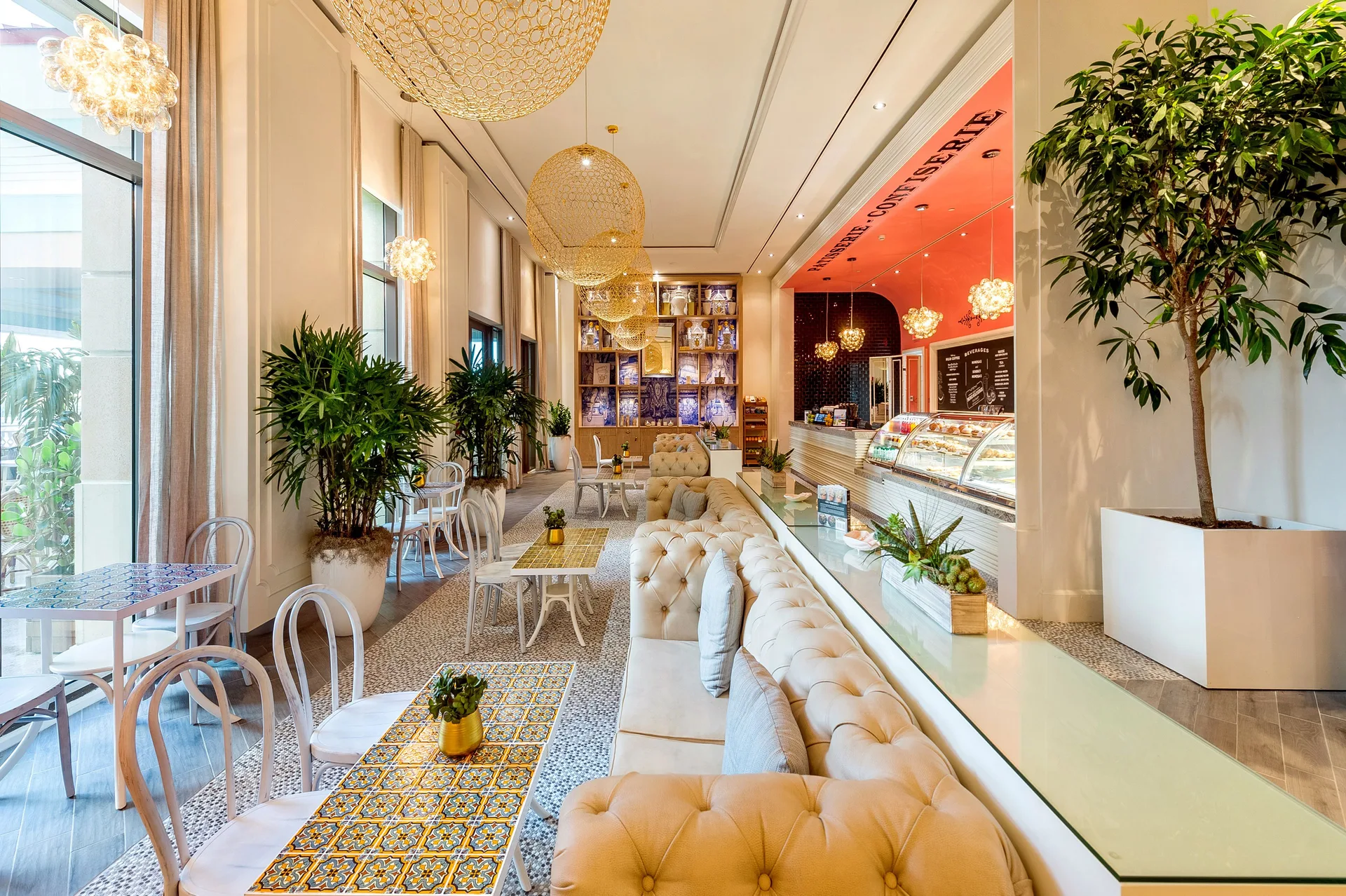 Café interior with tufted seating, tile tables, and a pastry counter at Grand Hyatt Baha Mar.