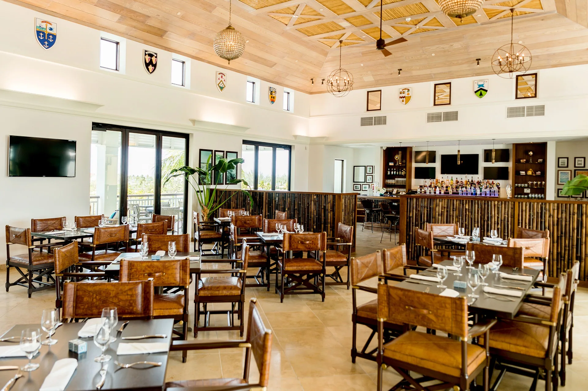 Bright restaurant dining room with bar, leather chairs, and high ceiling at Grand Hyatt Baha Mar.