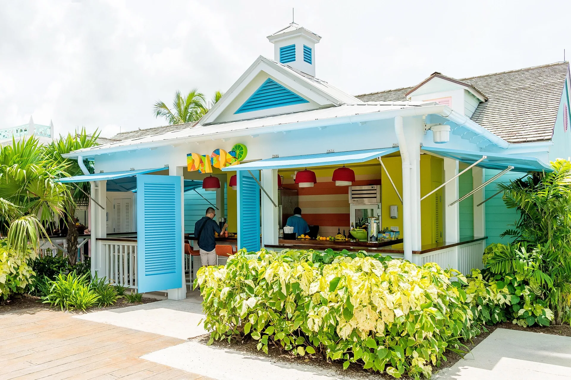 Colorful Daqs bar pavilion with blue shutters and tropical plantings at Grand Hyatt Baha Mar.