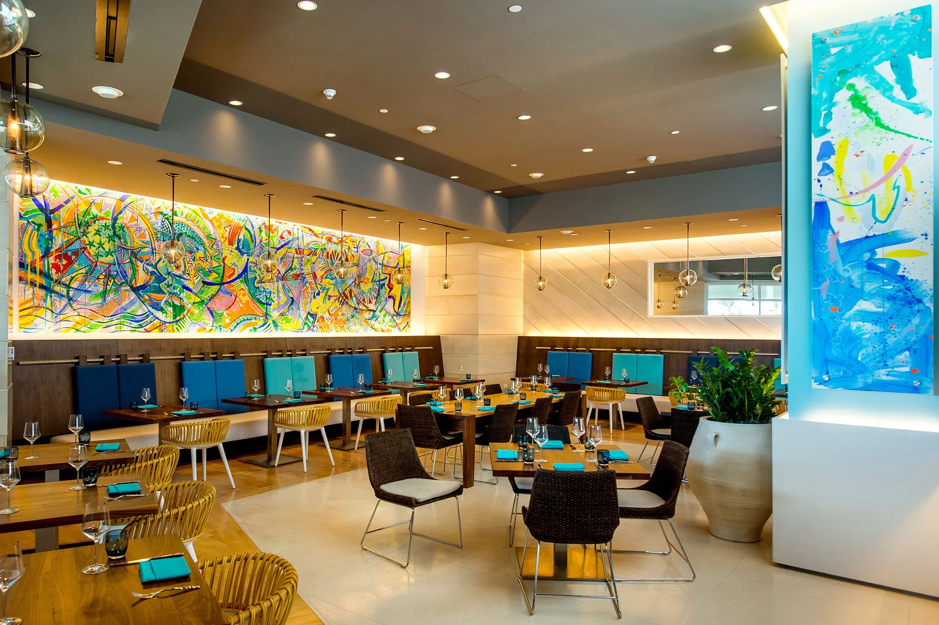 Modern dining room with colorful wall art and turquoise place settings at Grand Hyatt Baha Mar.