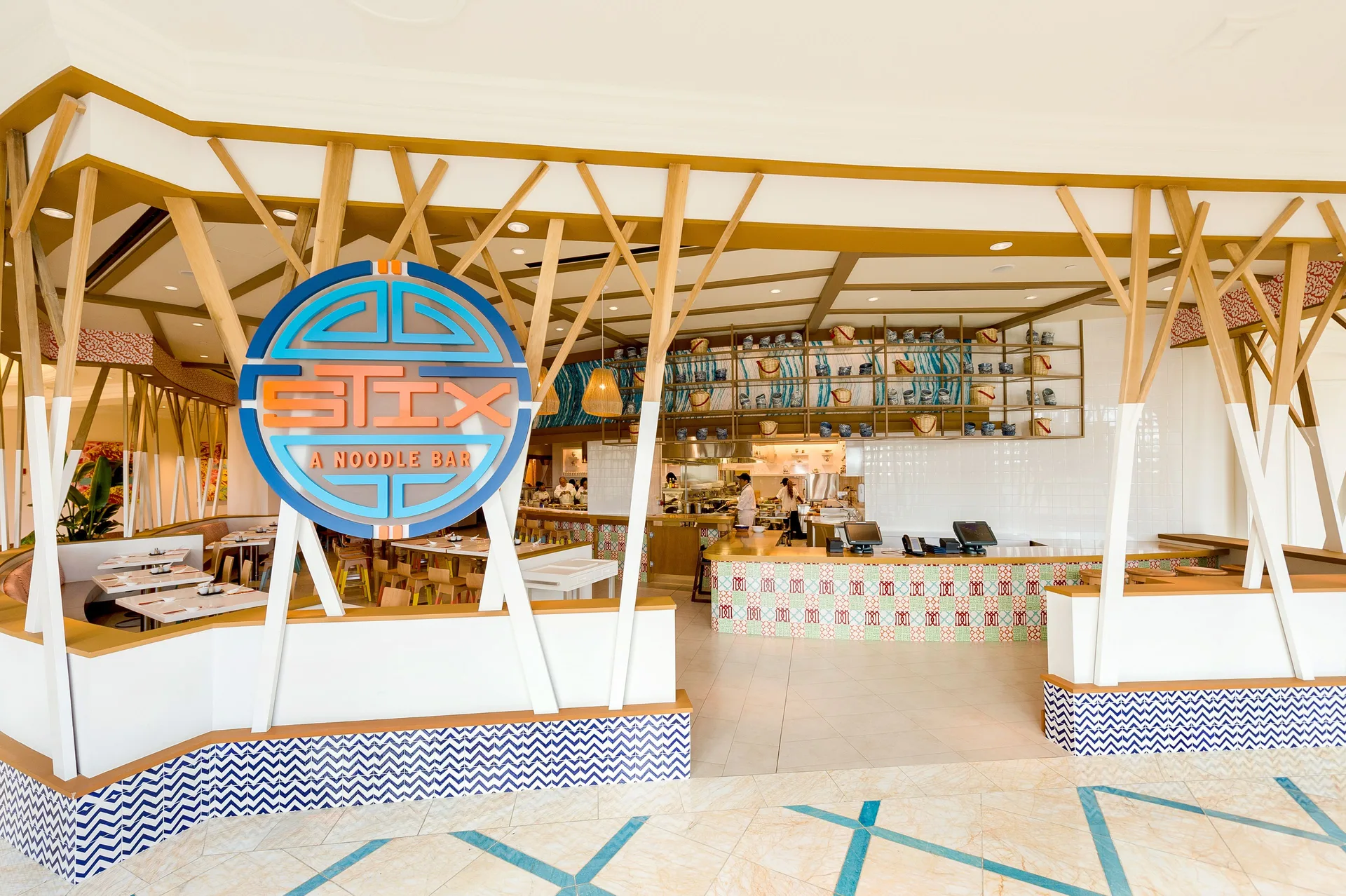 Stix noodle bar entrance with large round sign and open kitchen at Grand Hyatt Baha Mar.