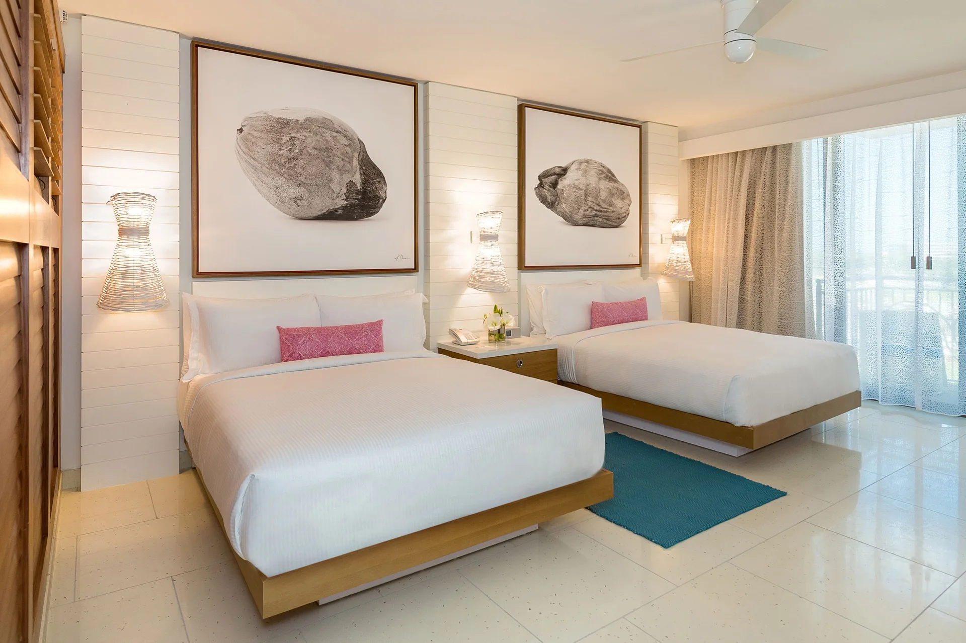 Two double beds in a Grand Room at Grand Hyatt Baha Mar with wall art and balcony curtains.