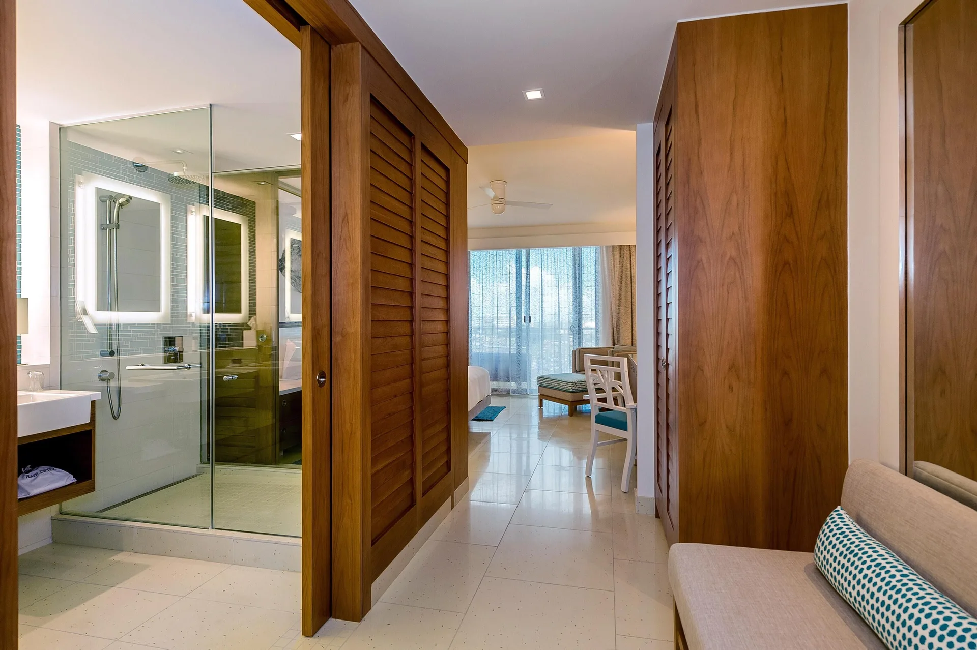 Grand Suite hallway with glass shower, wood closets, and bedroom beyond at Grand Hyatt Baha Mar.