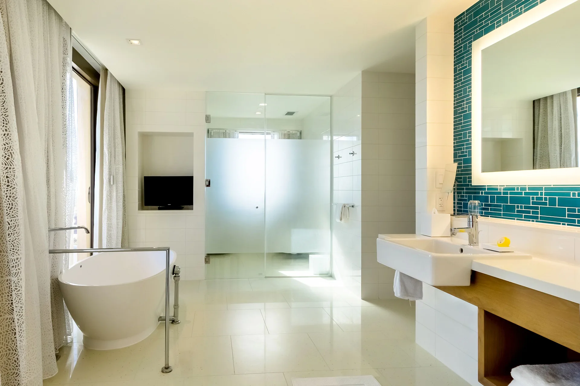 Grand Suite bathroom with soaking tub, glass shower, vanity, and blue tile at Grand Hyatt Baha Mar.
