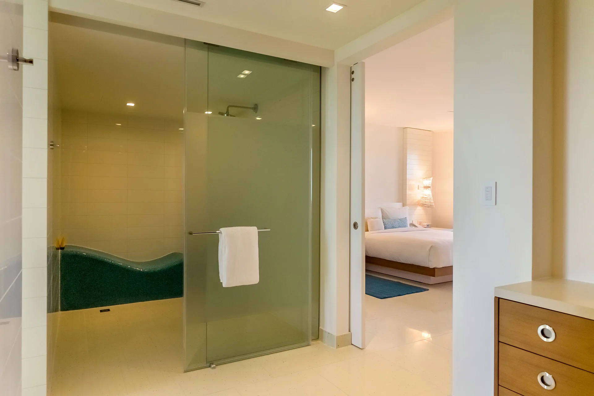 Grand Suite bathroom with glass shower and bedroom visible beyond at Grand Hyatt Baha Mar.