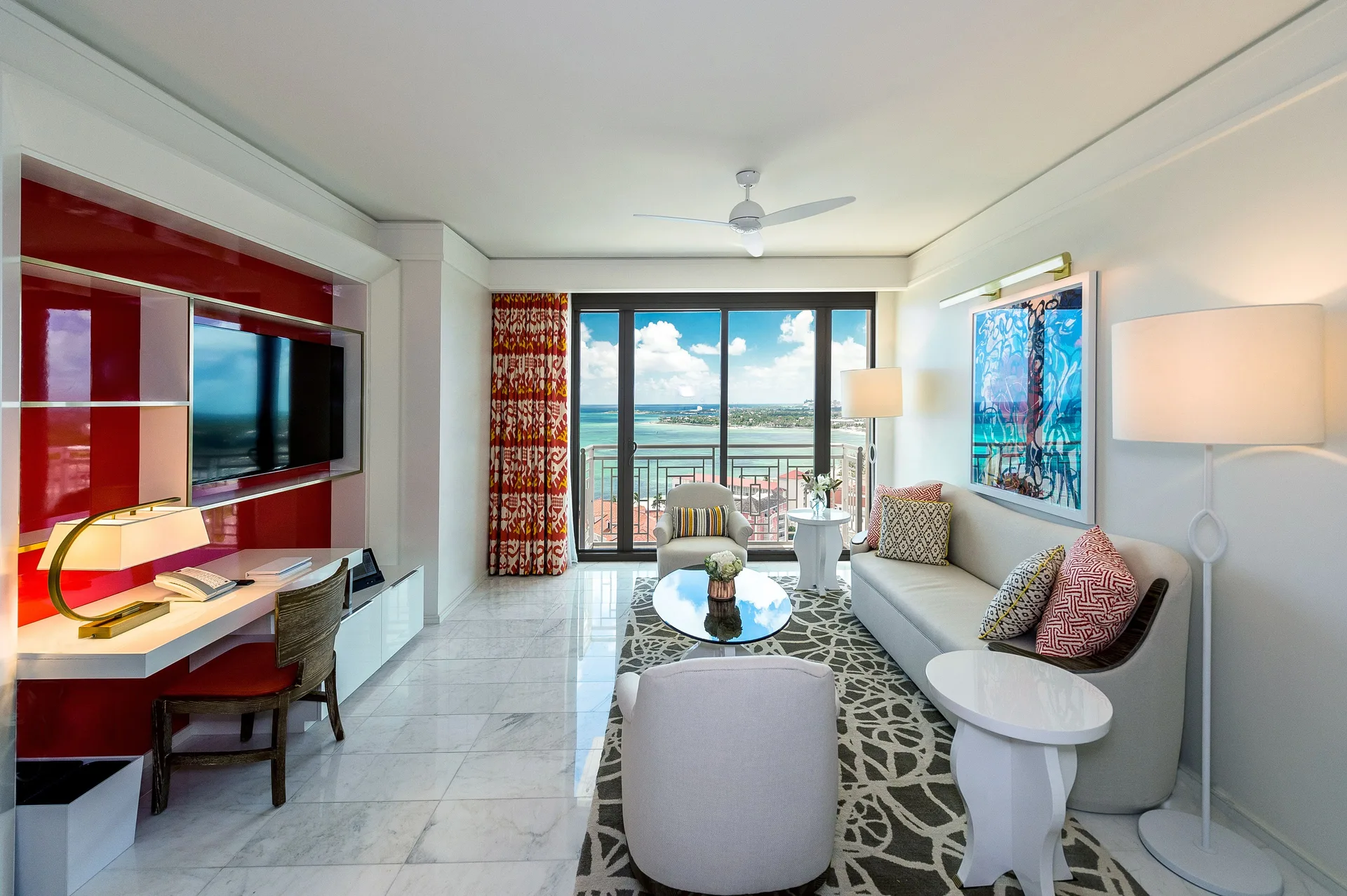 Residence living room with sofa, desk, TV, and balcony view at Grand Hyatt Baha Mar.