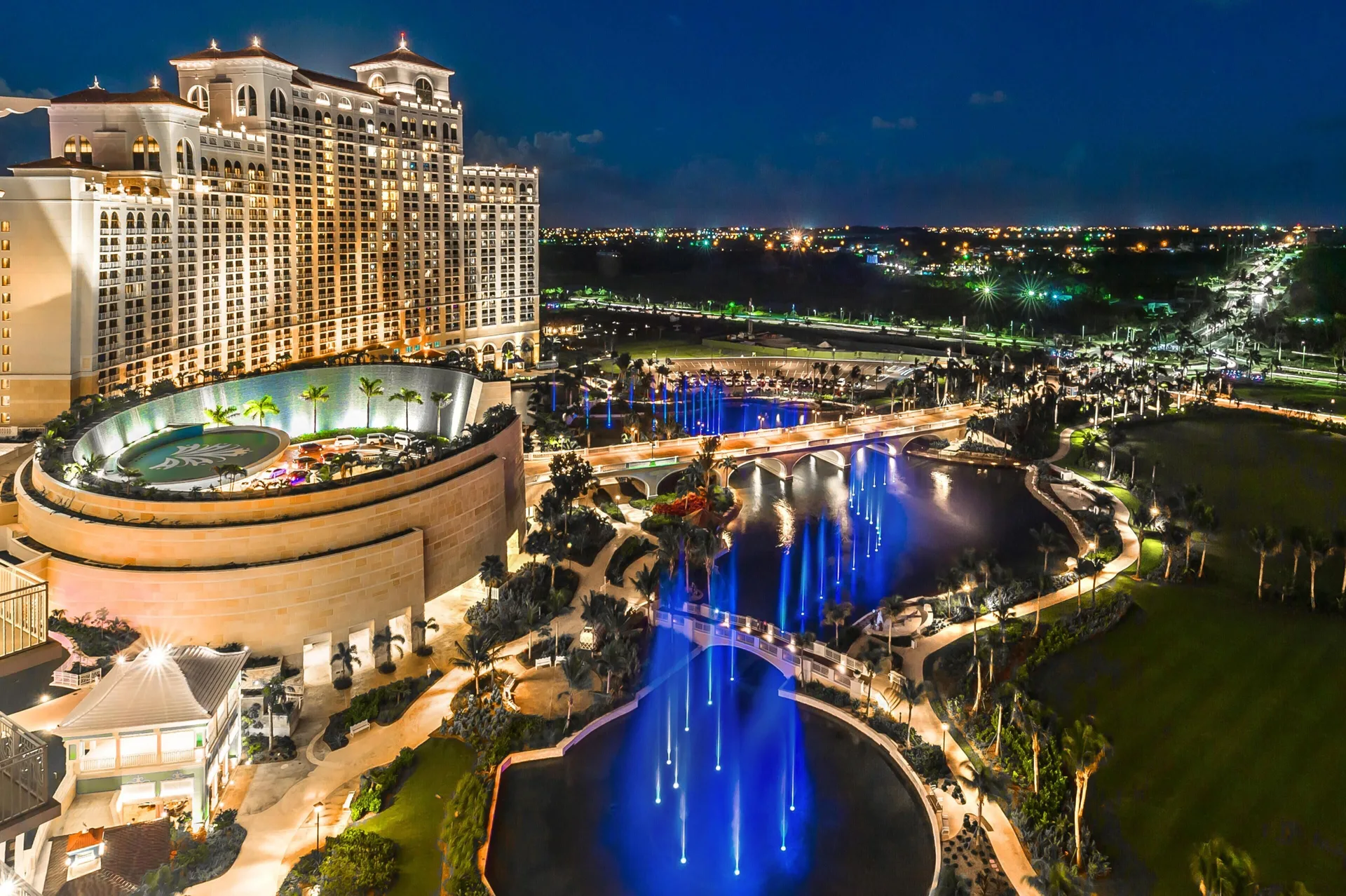 Nighttime view of illuminated fountains and hotel towers at Grand Hyatt Baha Mar.