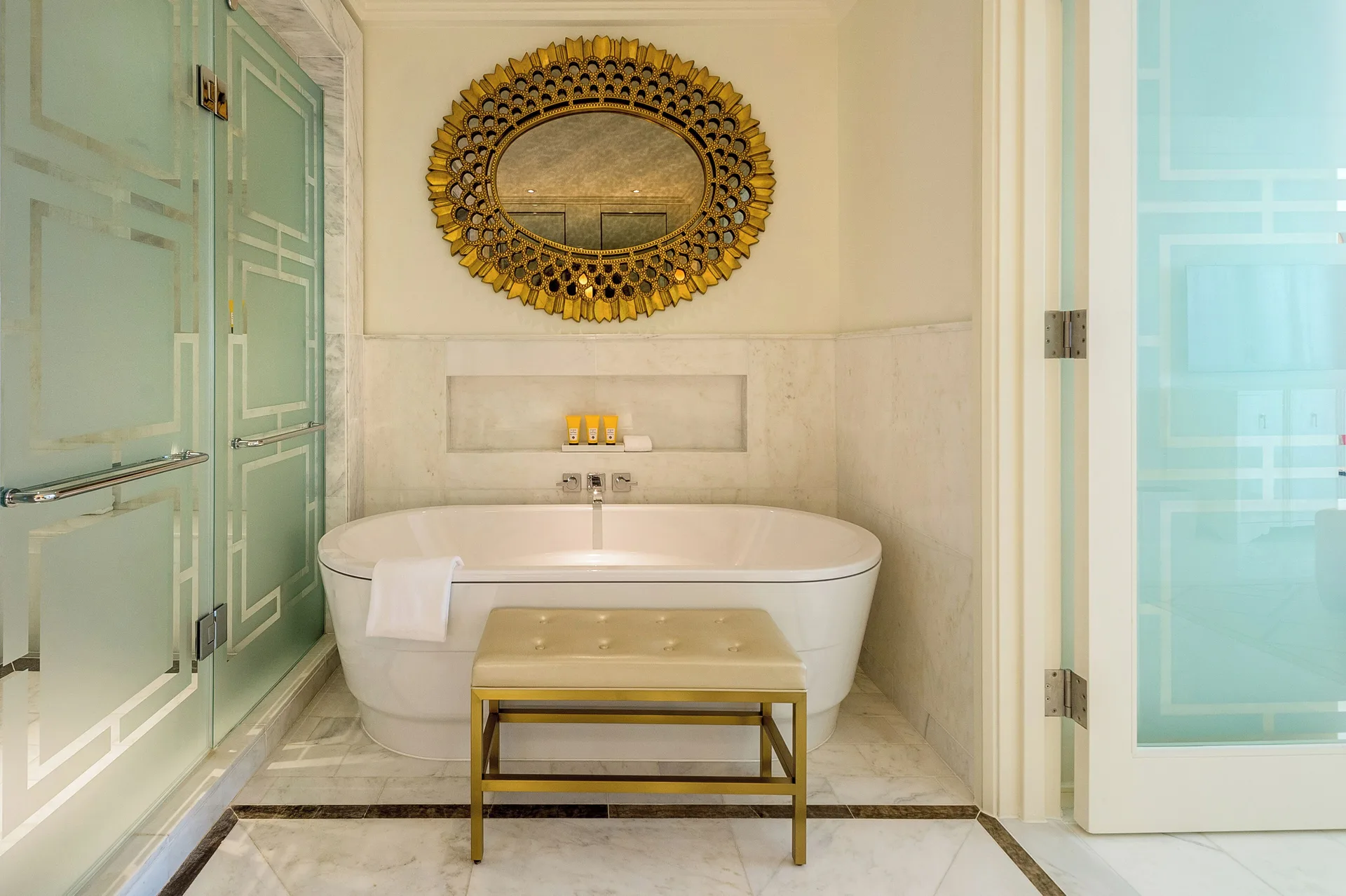 Bathtub, shower doors, and gold mirror in a residence bathroom at Grand Hyatt Baha Mar.