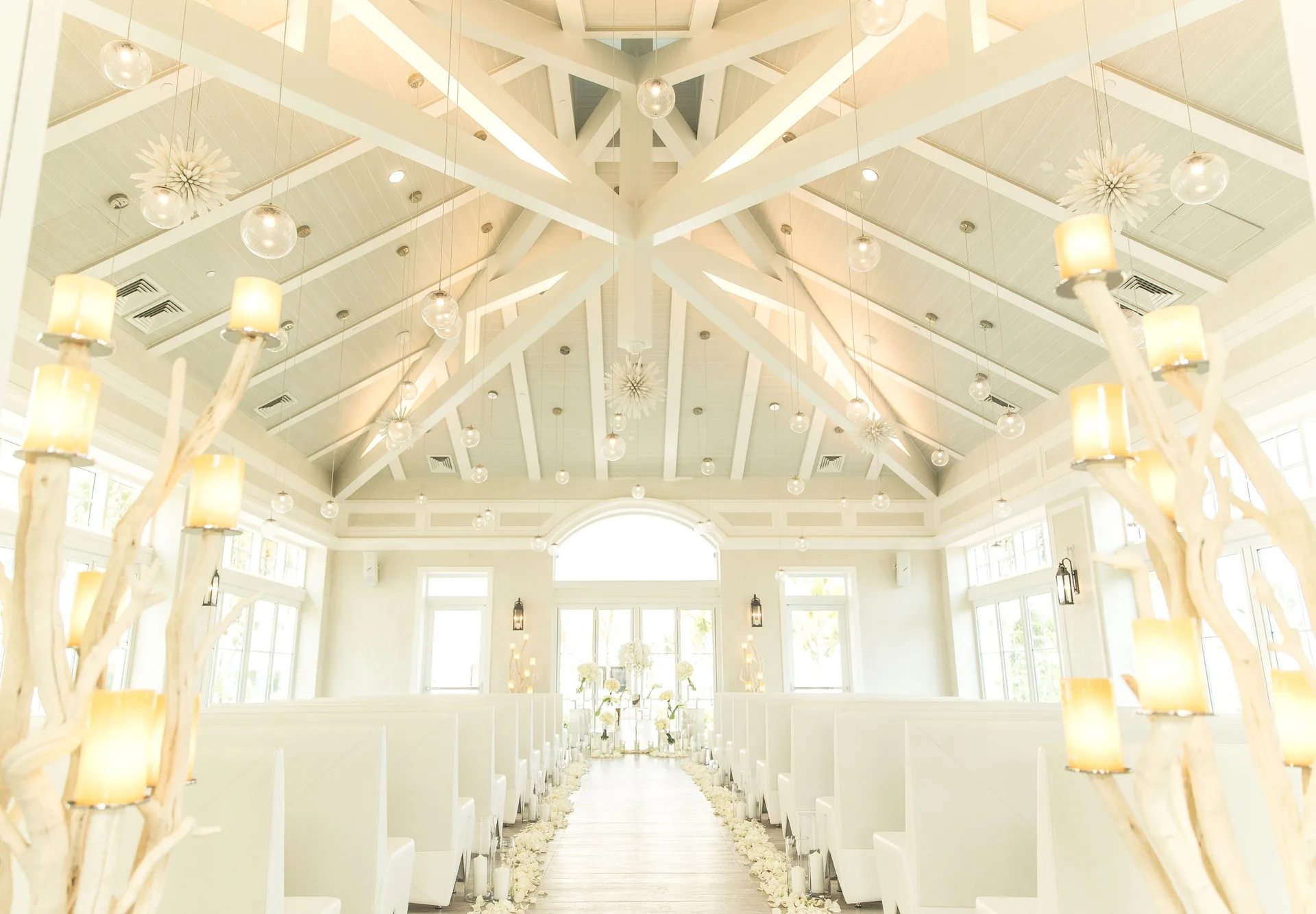 Wedding aisle with white benches and glowing candles at Grand Hyatt Baha Mar.