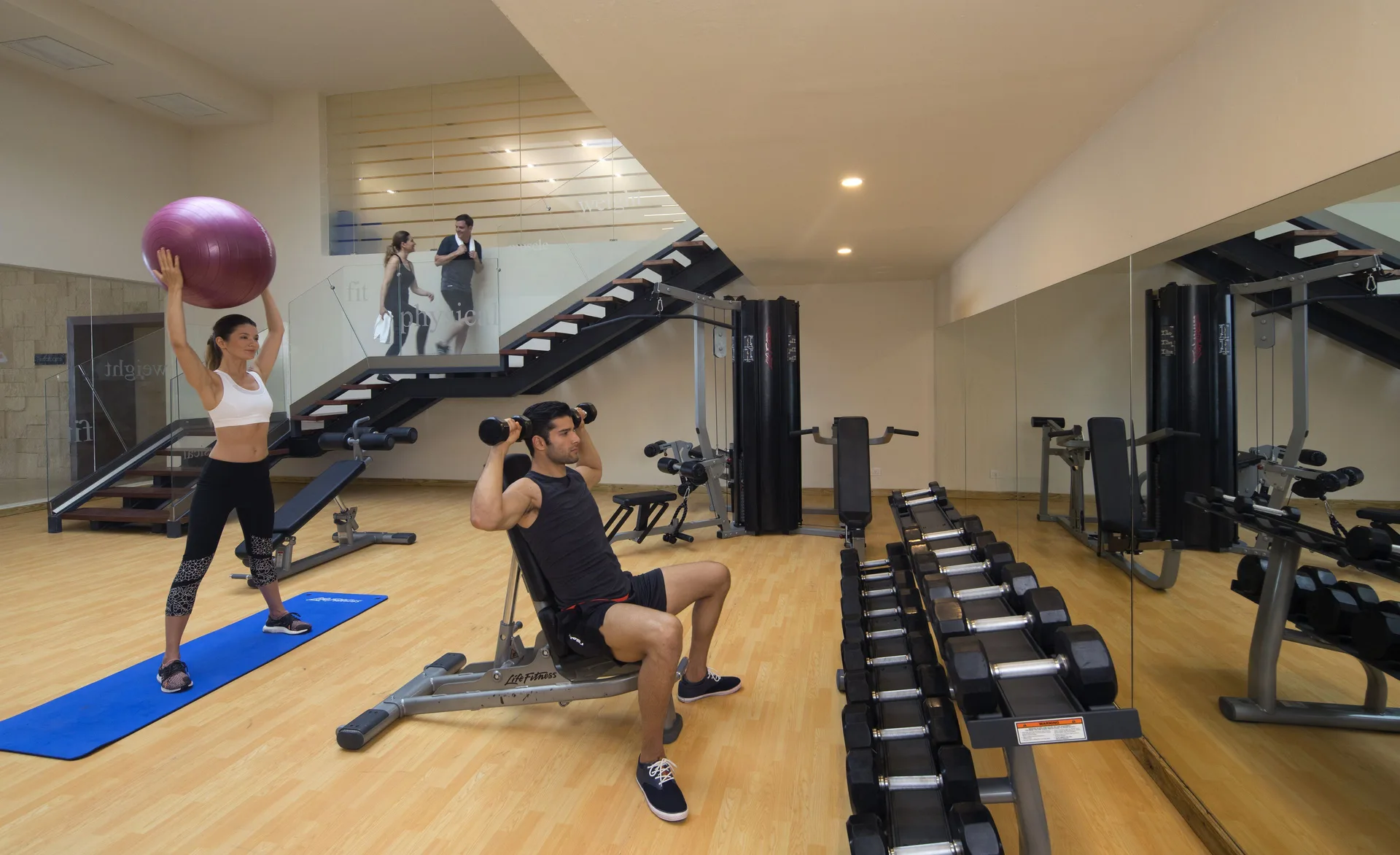 Guests exercising with weights and a fitness ball at Grand Lido Negril Au-Naturel.