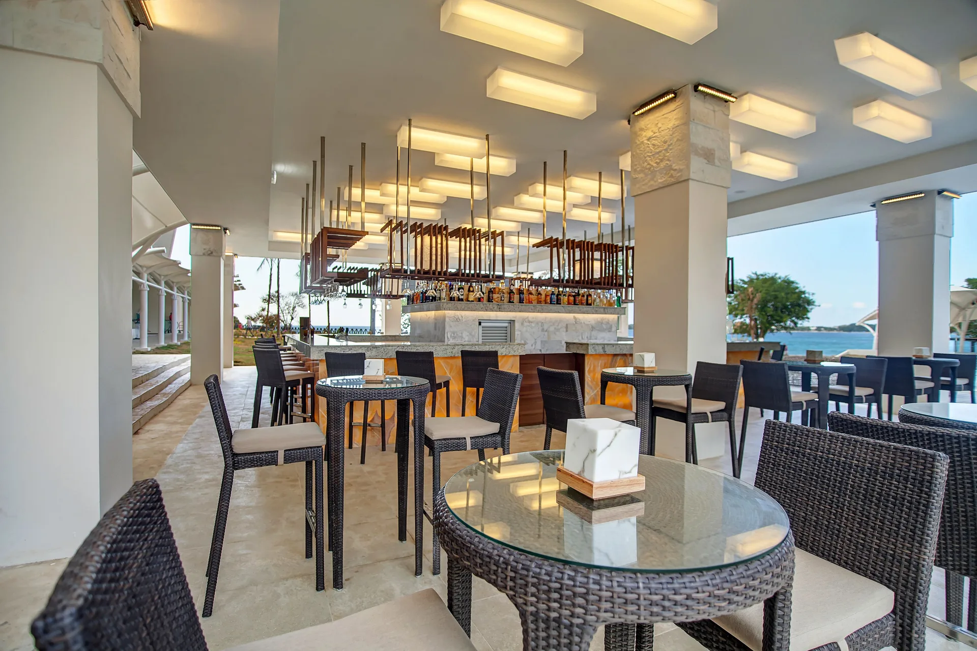 Open-air bar with wicker seating and ocean glimpses at Grand Lido Negril Au-Naturel.