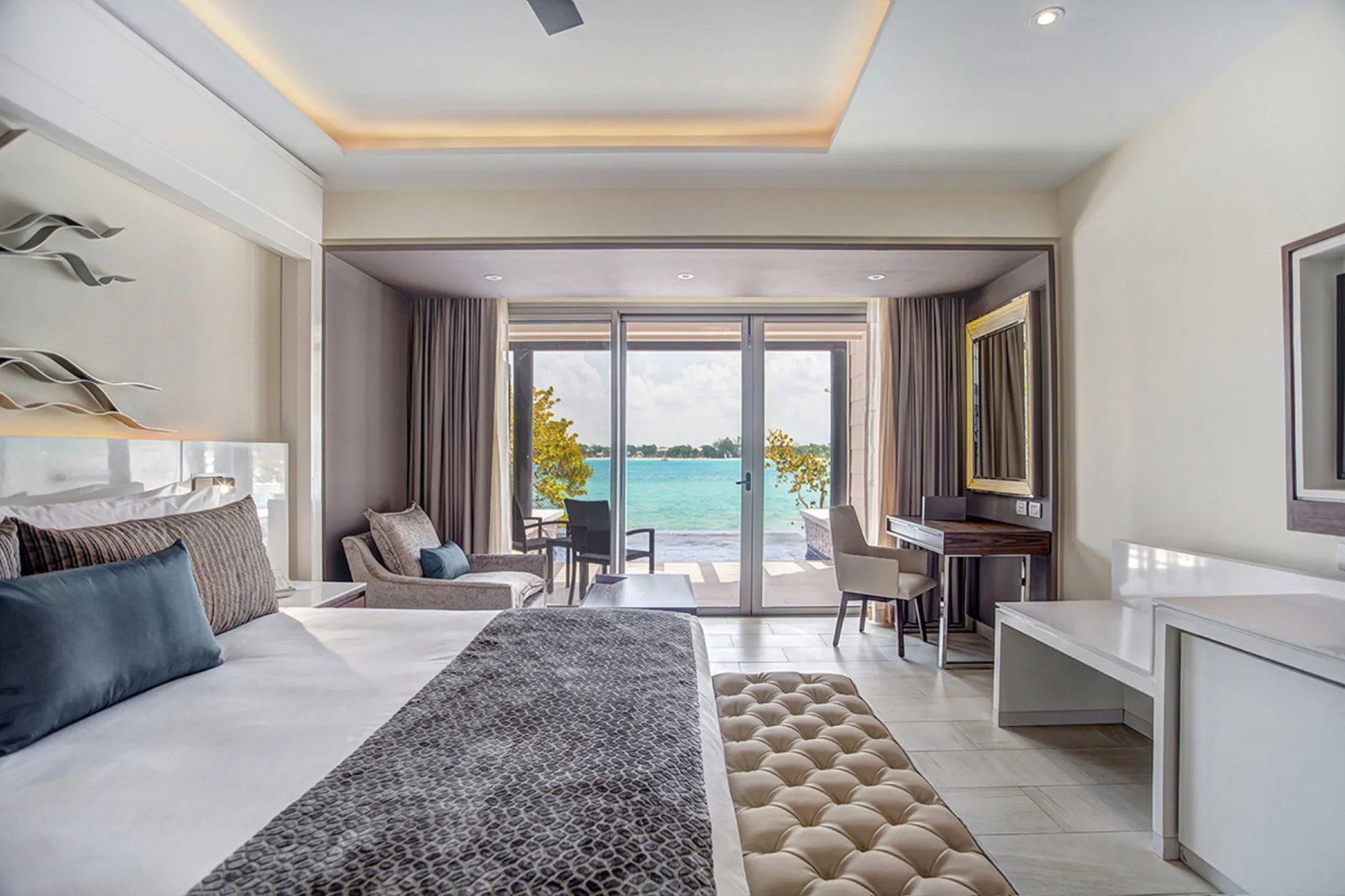 Sunset Ocean View Suite king bed with terrace doors and sea view at Grand Lido Negril Au-Naturel.