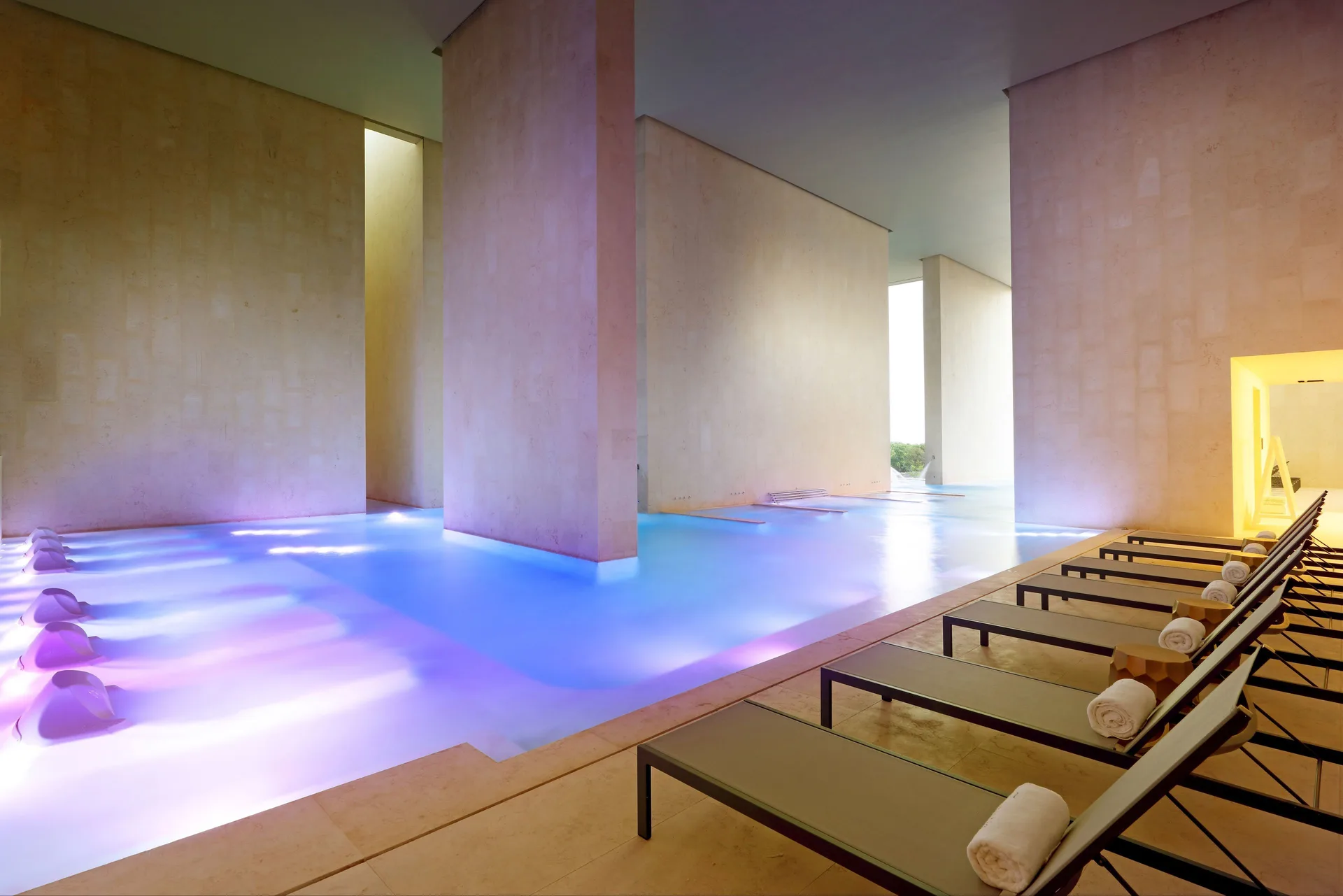 Indoor spa pool with loungers and towels at Grand Palladium Select Costa Mujeres.