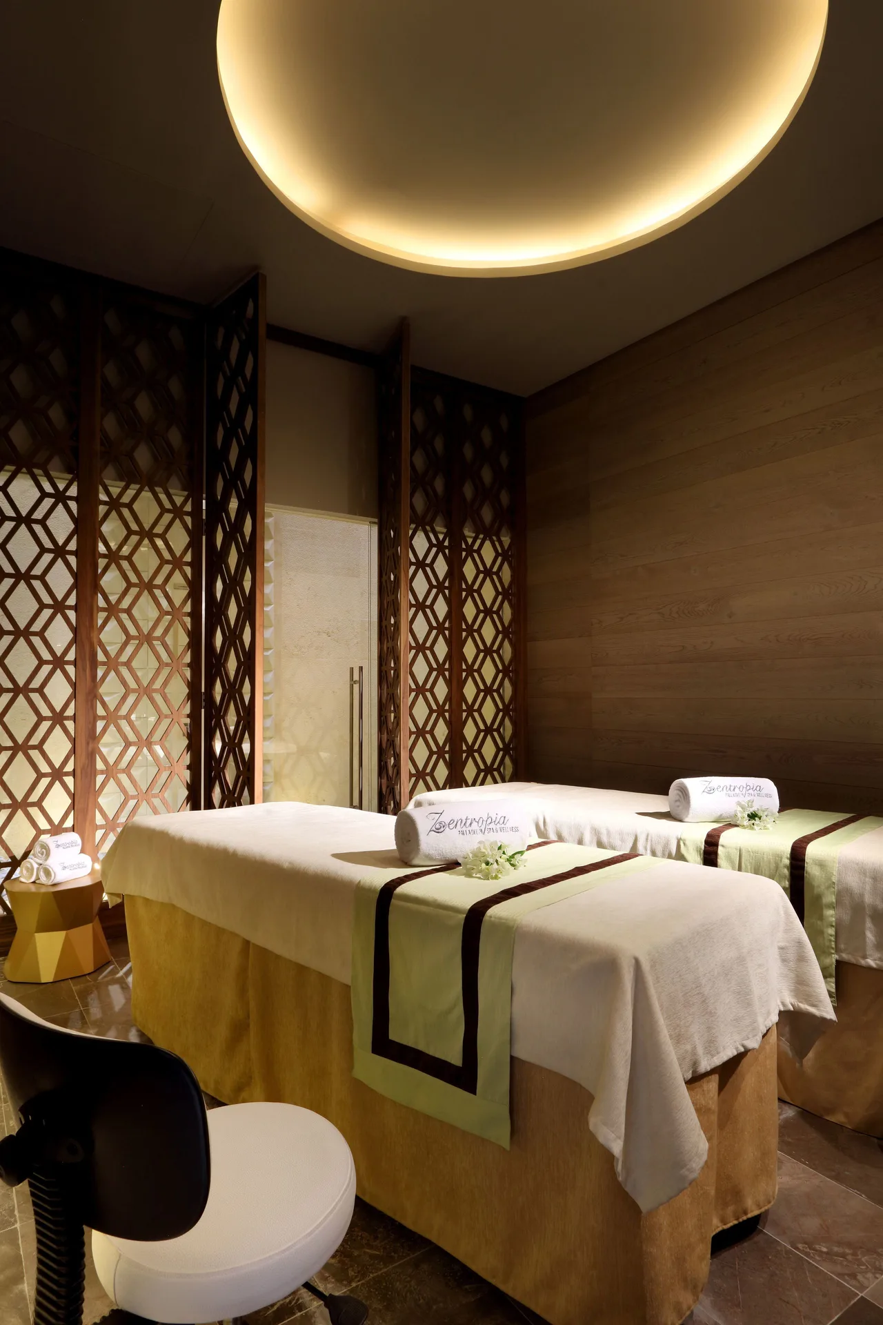 Twin spa treatment beds in a wood-paneled room at Grand Palladium Select Costa Mujeres.