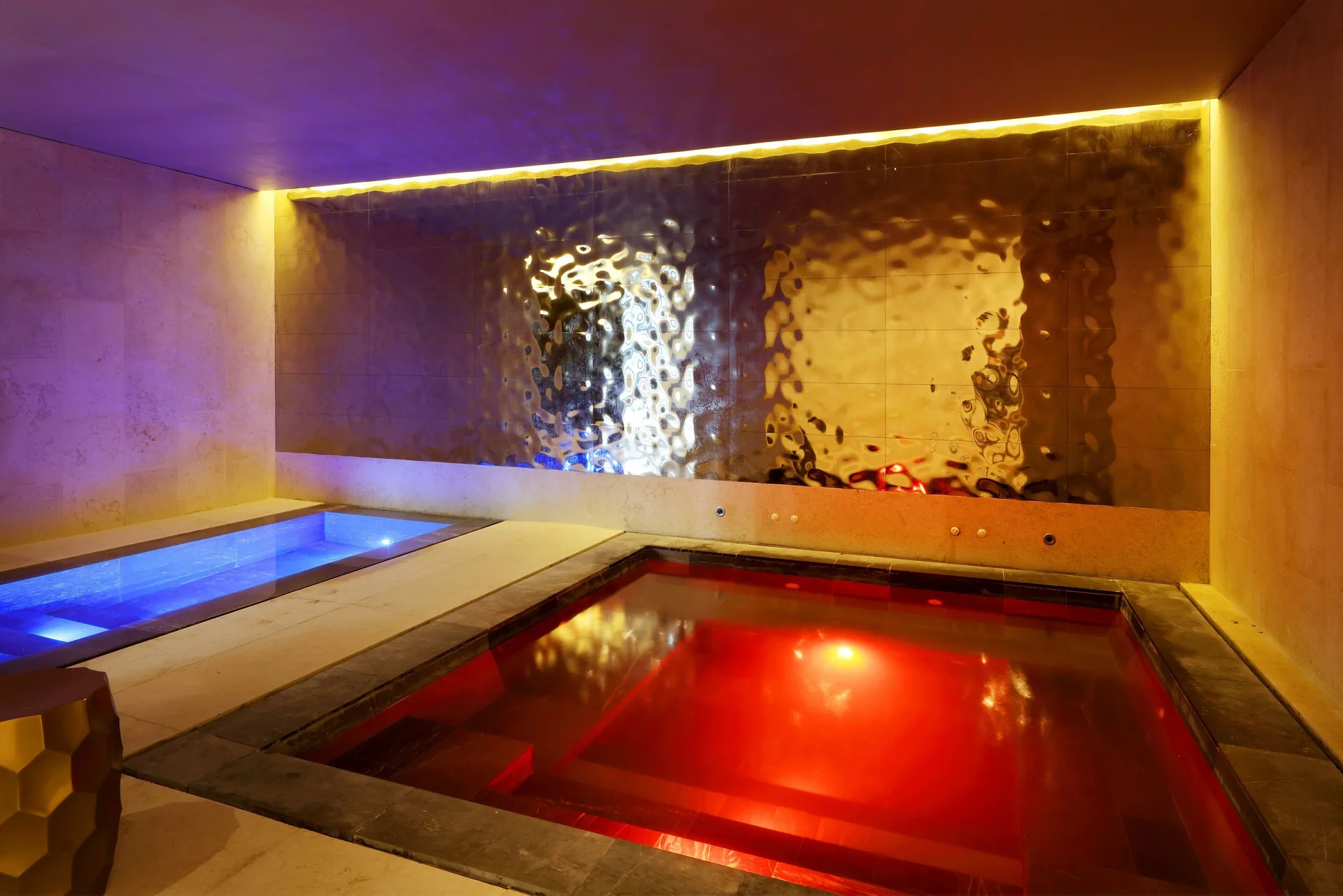 Thermal spa pools glow red and blue at Grand Palladium Select Costa Mujeres.