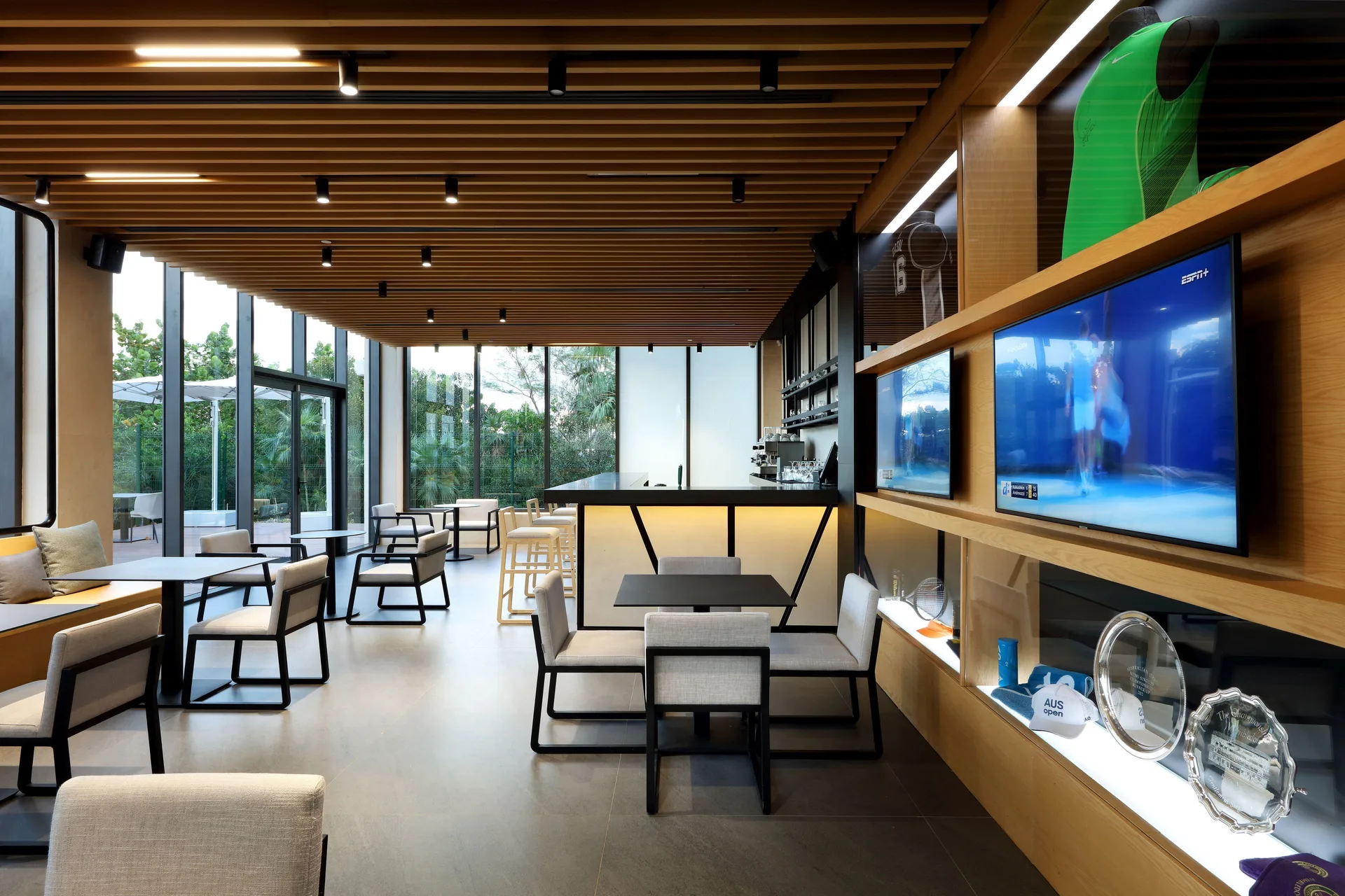 Sports bar lounge with TVs, trophy displays, and bar seating at Grand Palladium Select Costa Mujeres.