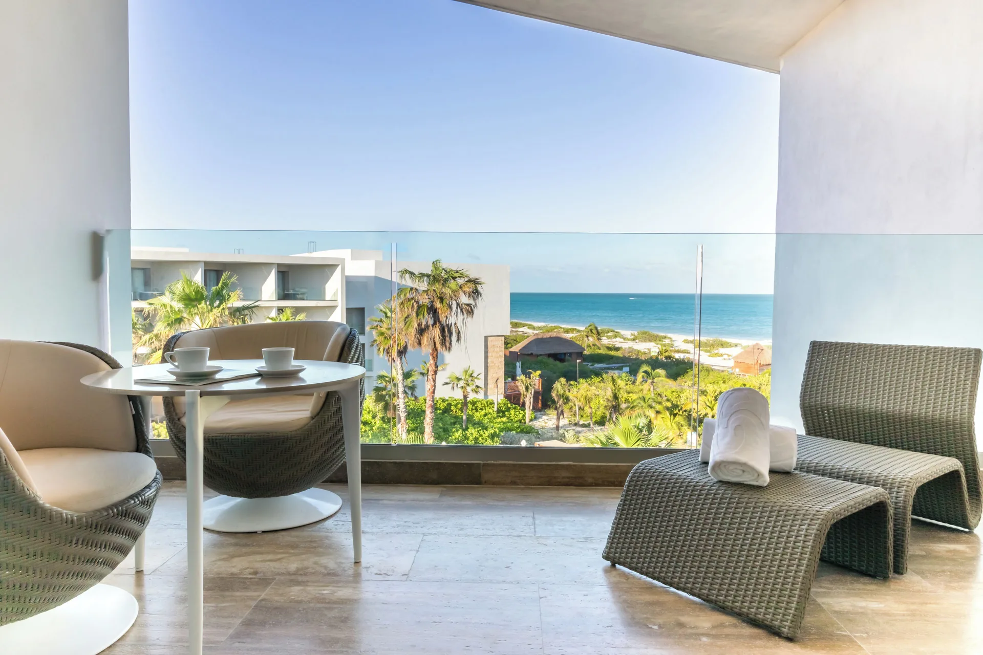 Junior Suite Ocean View balcony with lounge chairs and sea view at Grand Palladium Select Costa Mujeres.