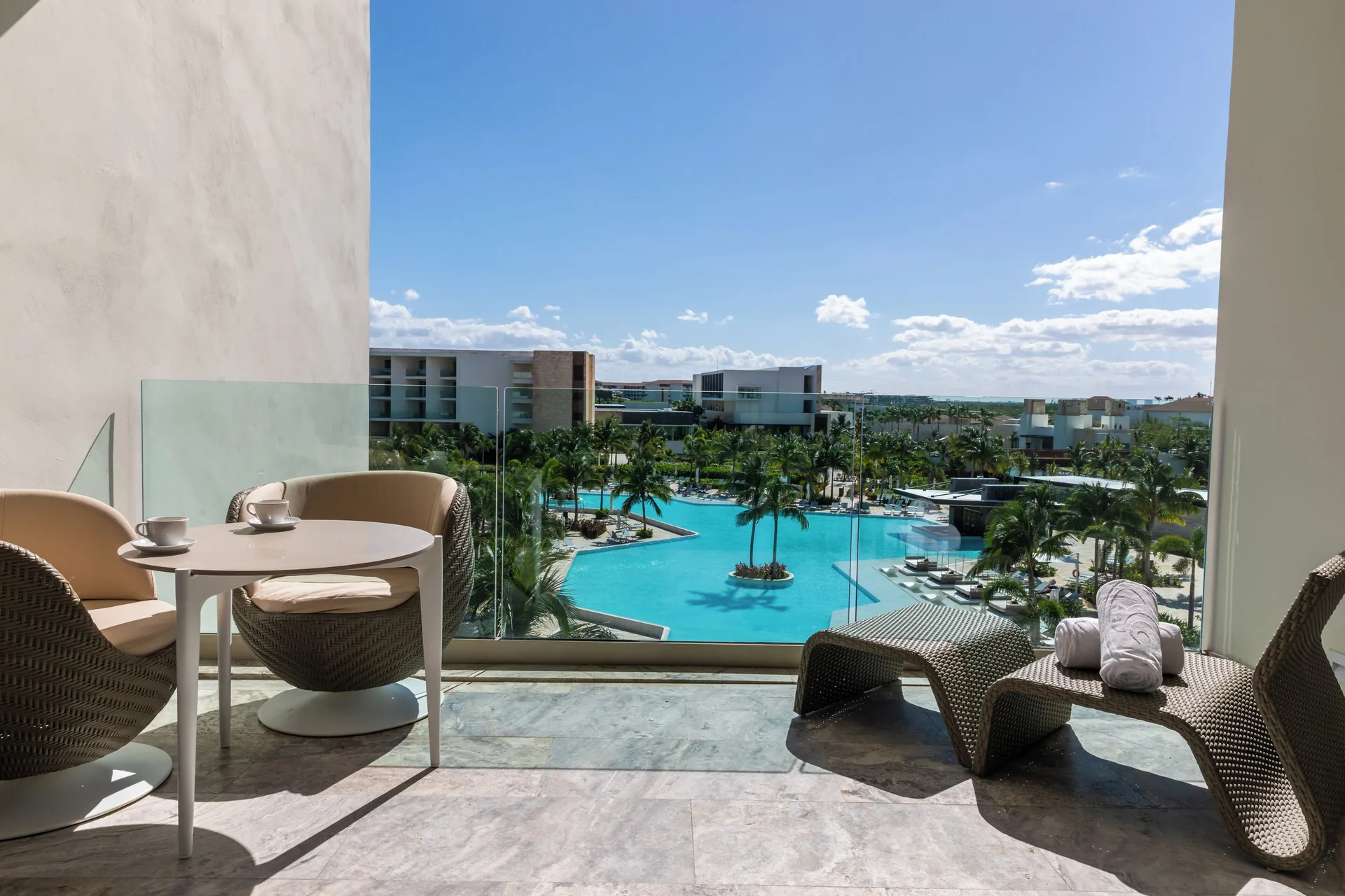 Junior Suite Poolside balcony with seating and pool view at Grand Palladium Select Costa Mujeres.
