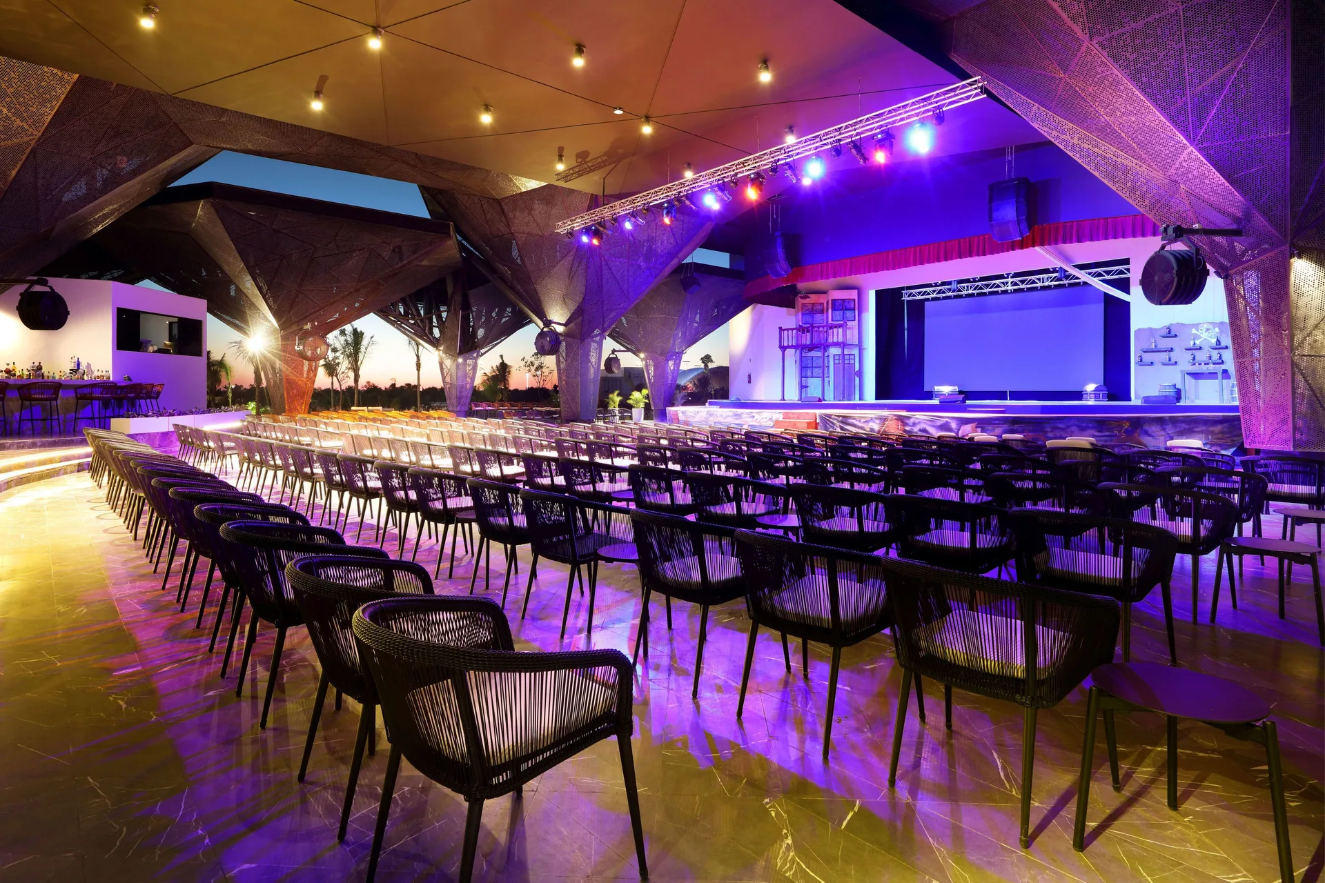 Open-air show venue with stage lighting and rows of chairs at Grand Palladium Select Costa Mujeres.