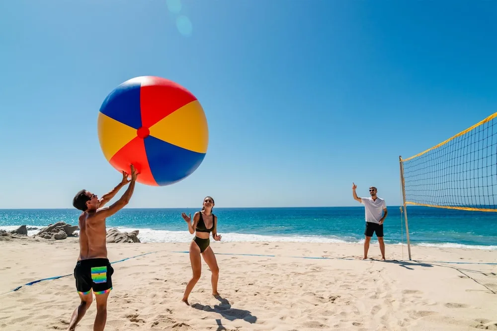 Guests play beach volleyball with a giant ball at Grand Velas Los Cabos.