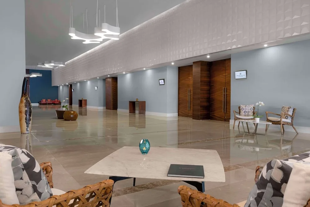 A polished elevator lobby with seating and wood doors at Grand Velas Los Cabos.
