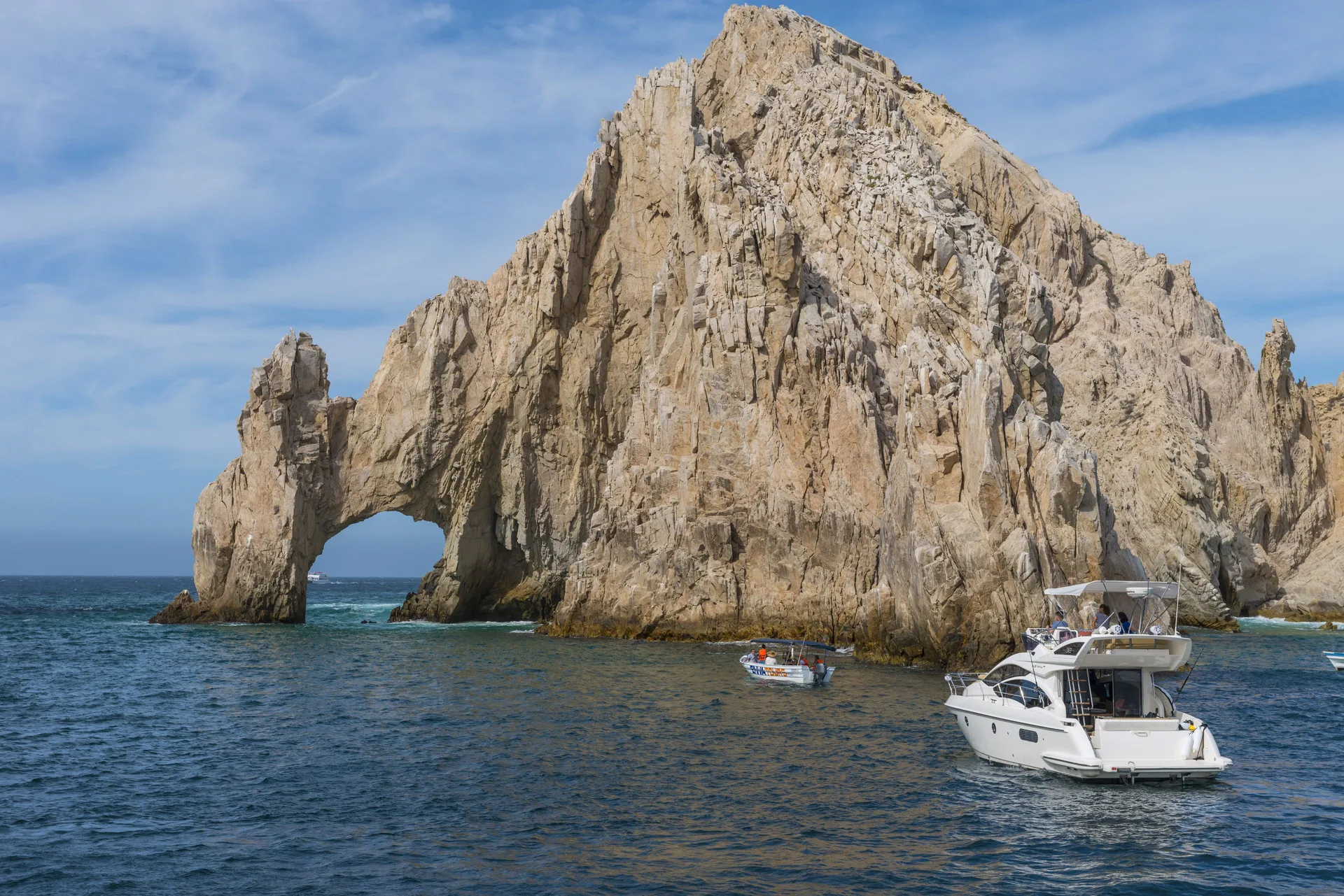 Land's End rock arch with boats on the water near Grand Velas Los Cabos.