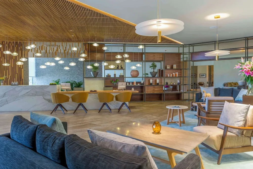 Spa reception lounge with seating, shelves, and pendant lights at Grand Velas Los Cabos.