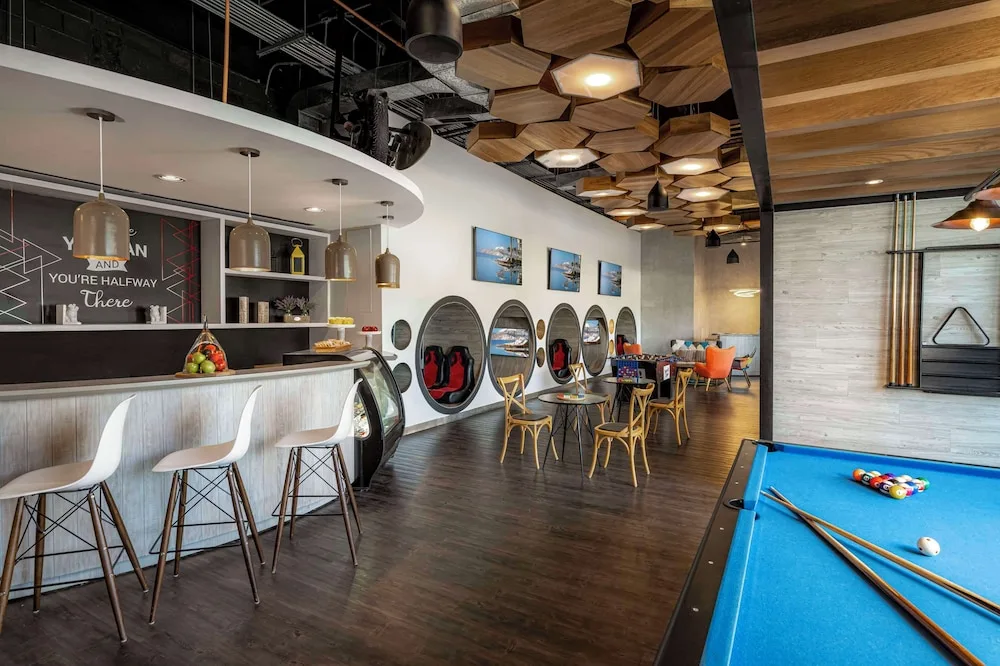 Teen lounge with pool table, café counter, and game pods at Grand Velas Los Cabos.