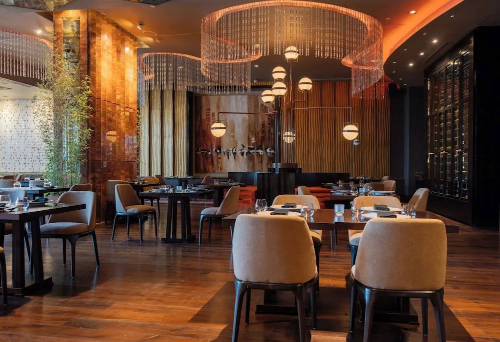 Elegant dining room with circular chandeliers at Grand Velas Los Cabos.