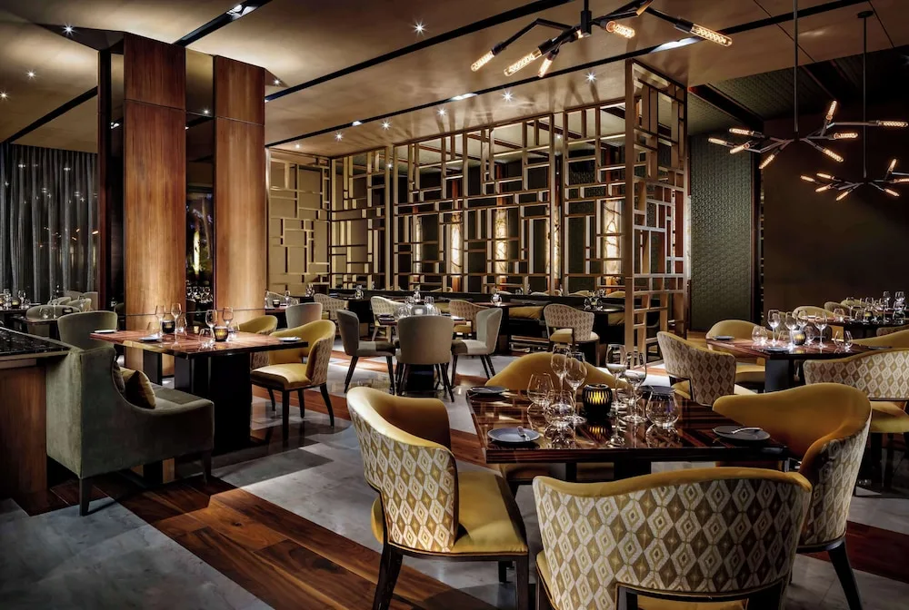 Modern dining room with patterned chairs and lattice partitions at Grand Velas Los Cabos.