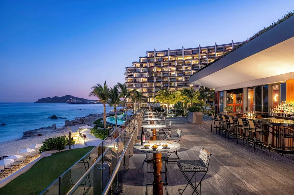 Oceanview terrace bar with resort buildings in the background at Grand Velas Los Cabos.