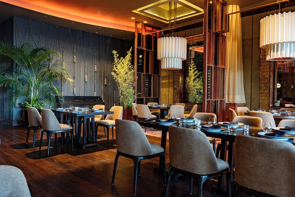 Restaurant dining room with plants and paneled walls at Grand Velas Los Cabos.