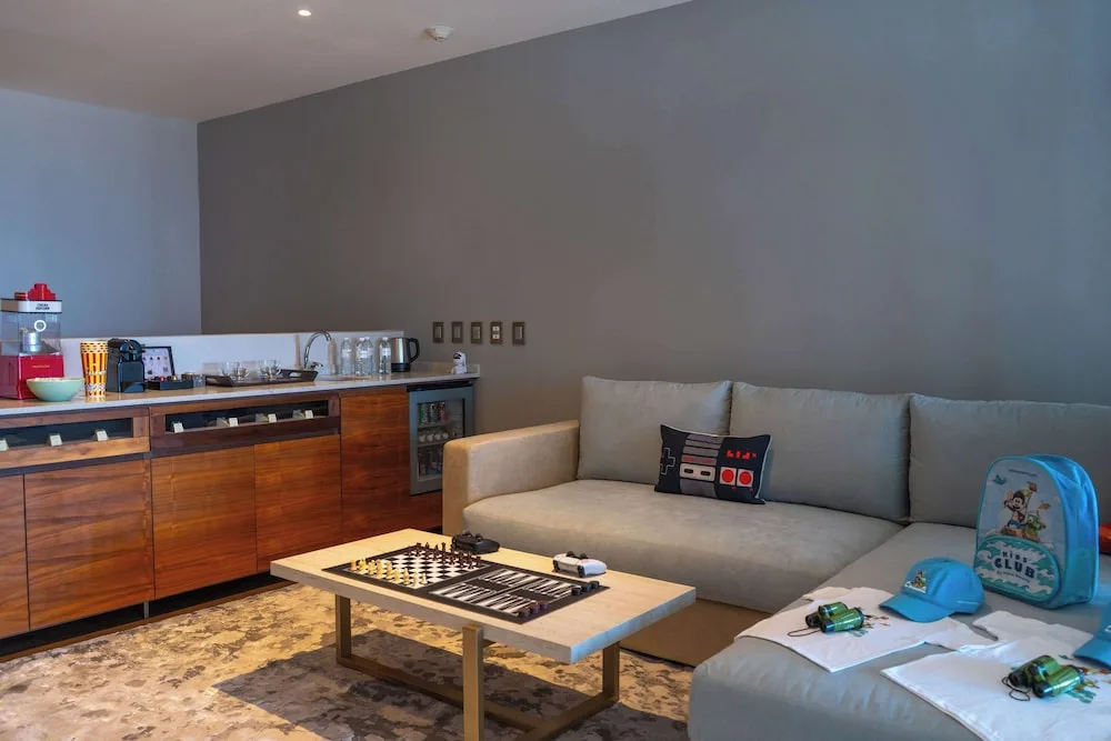 Family Duplex lounge with sofa, games, and refreshment counter at Grand Velas Los Cabos.