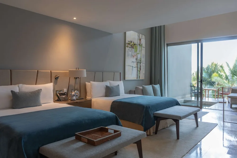 Family Duplex bedroom with two beds and balcony at Grand Velas Los Cabos.