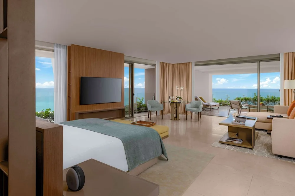 Grand Class Corner Suite with king bed, lounge area, terrace, and ocean view at Grand Velas Los Cabos.