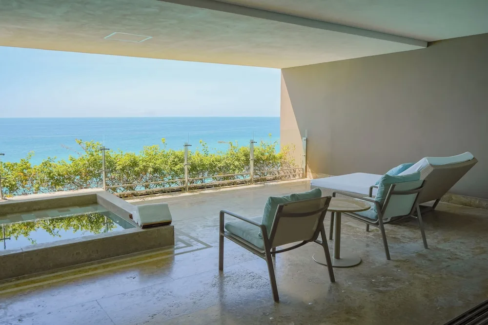 Grand Class Corner Suite terrace with plunge pool, chairs, chaise, and ocean view at Grand Velas Los Cabos.