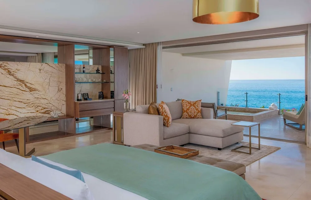 Grand Class Suite Ocean Front king bed, lounge, and ocean view at Grand Velas Los Cabos.