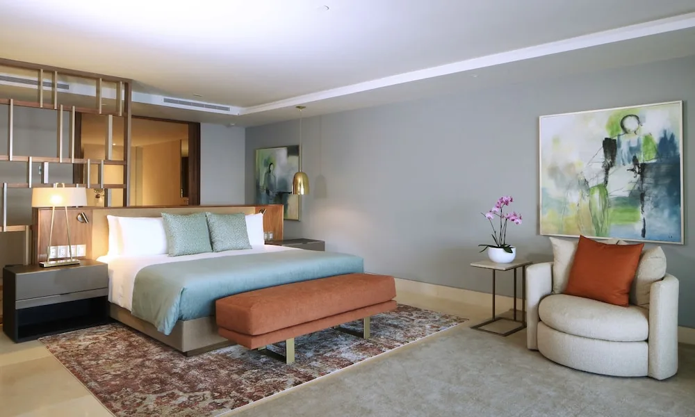 One Bedroom Governor Suite king bed and lounge chair at Grand Velas Los Cabos.