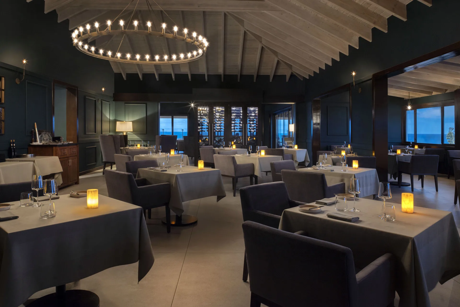 Candlelit fine-dining room with ocean-view windows at Hammock Cove Antigua.