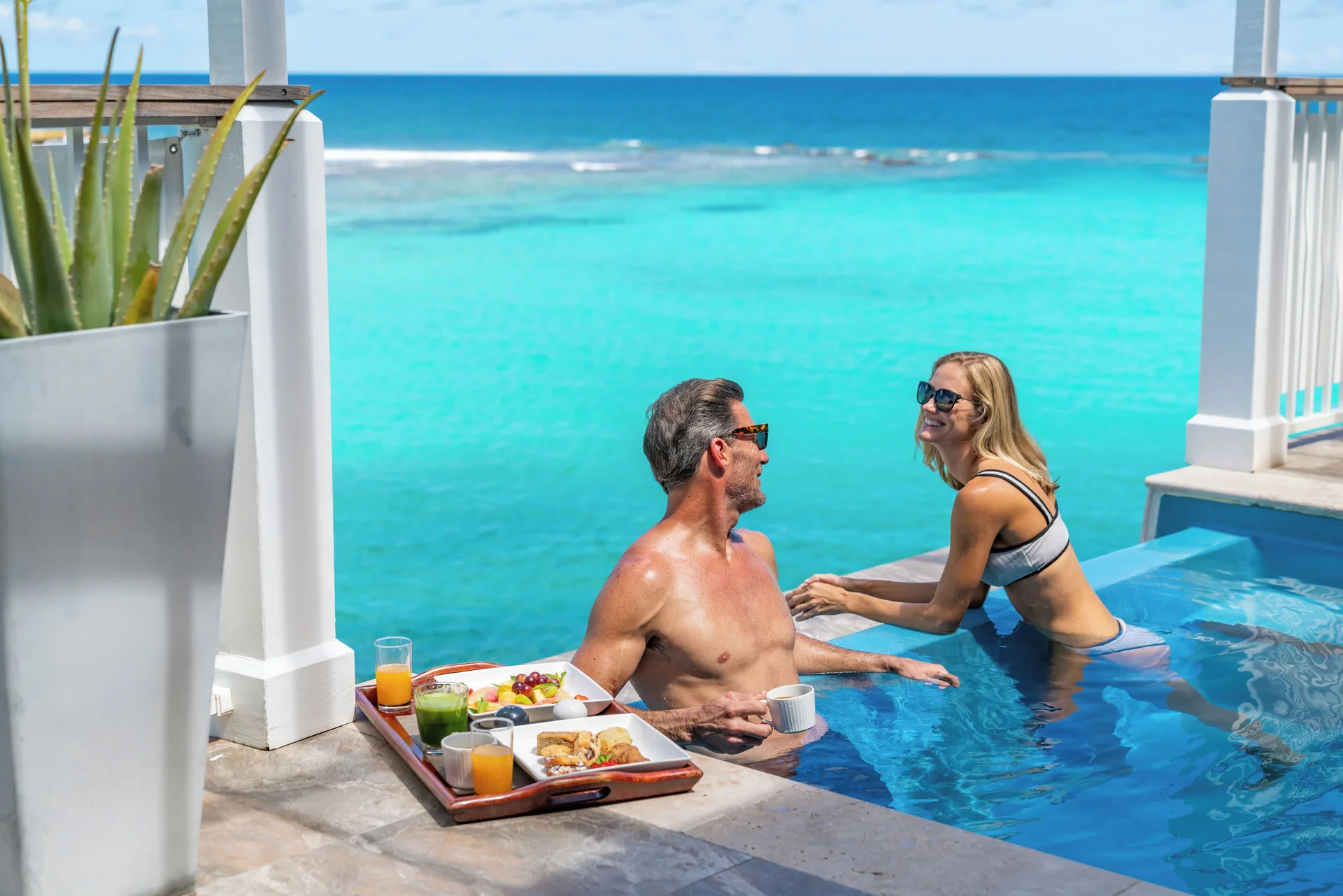 Guests in a Waterfront Villa plunge pool overlooking the sea at Hammock Cove Antigua.
