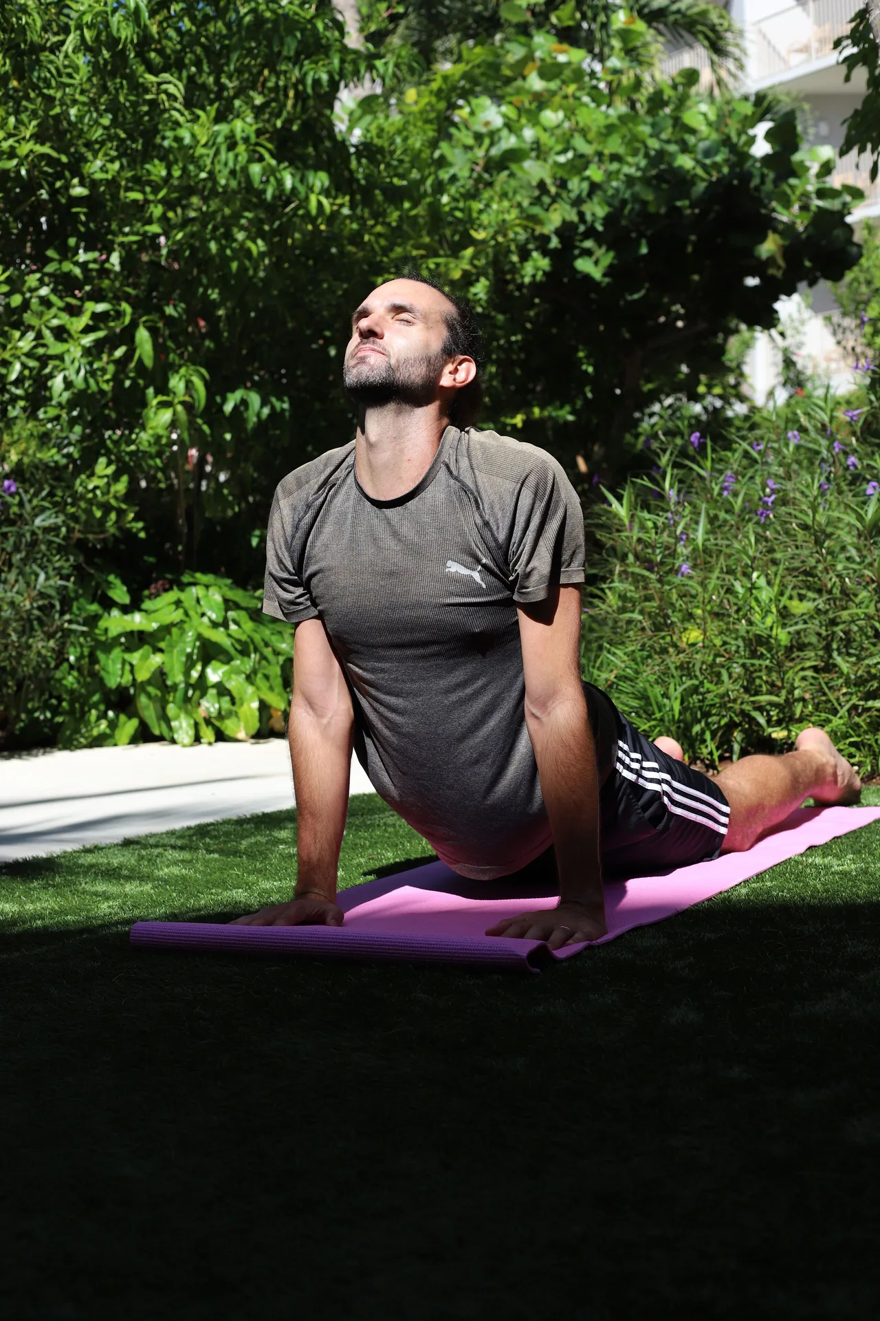 Guest doing yoga in the gardens at Hampton by Hilton Grand Cayman Seven Mile Beach.