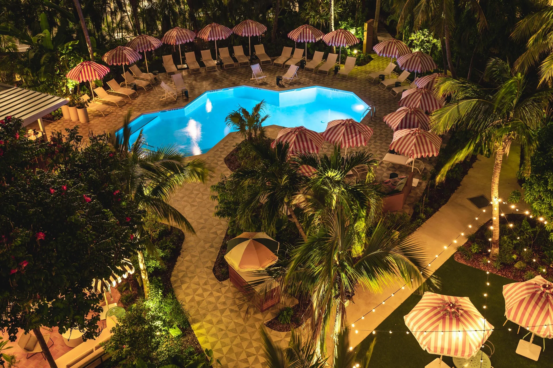 Nighttime resort pool and tropical grounds at Hampton by Hilton Grand Cayman Seven Mile Beach.