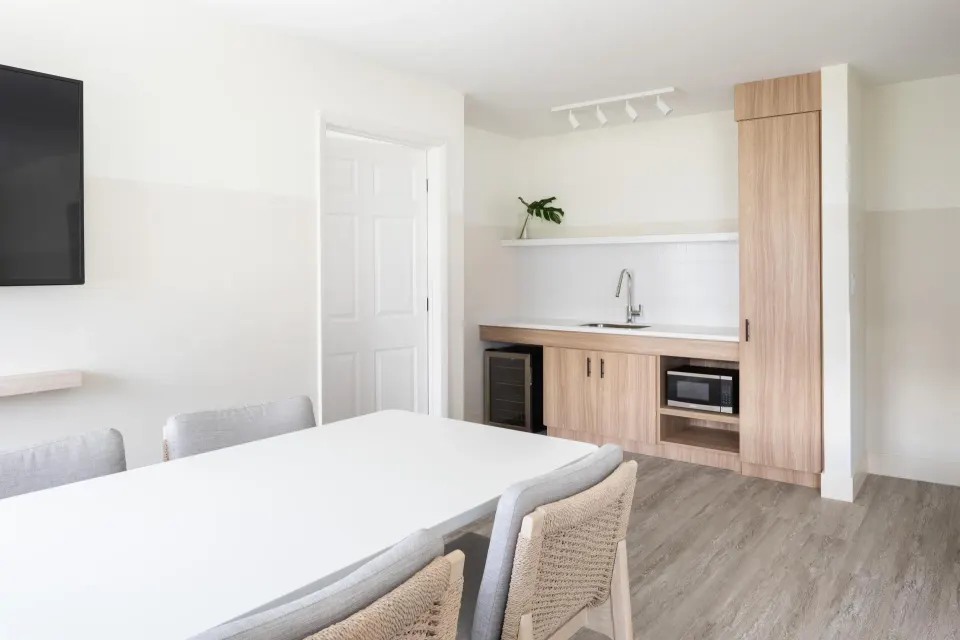Executive Suite dining and kitchenette at Hampton by Hilton Grand Cayman Seven Mile Beach with table and sink.
