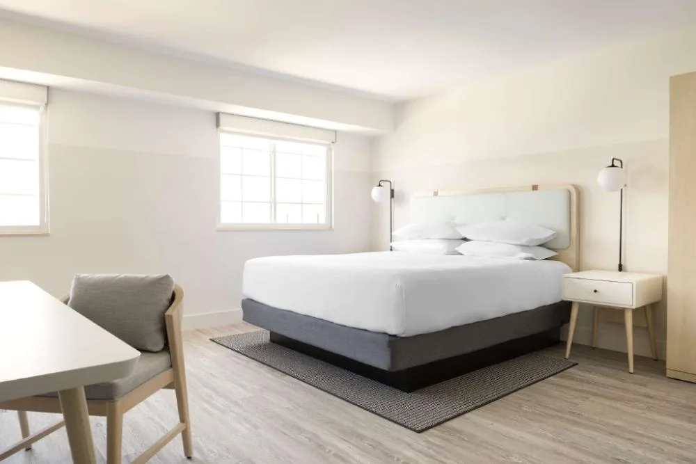 Standard guest room with bed, desk, and chair at Hampton by Hilton Grand Cayman Seven Mile Beach.