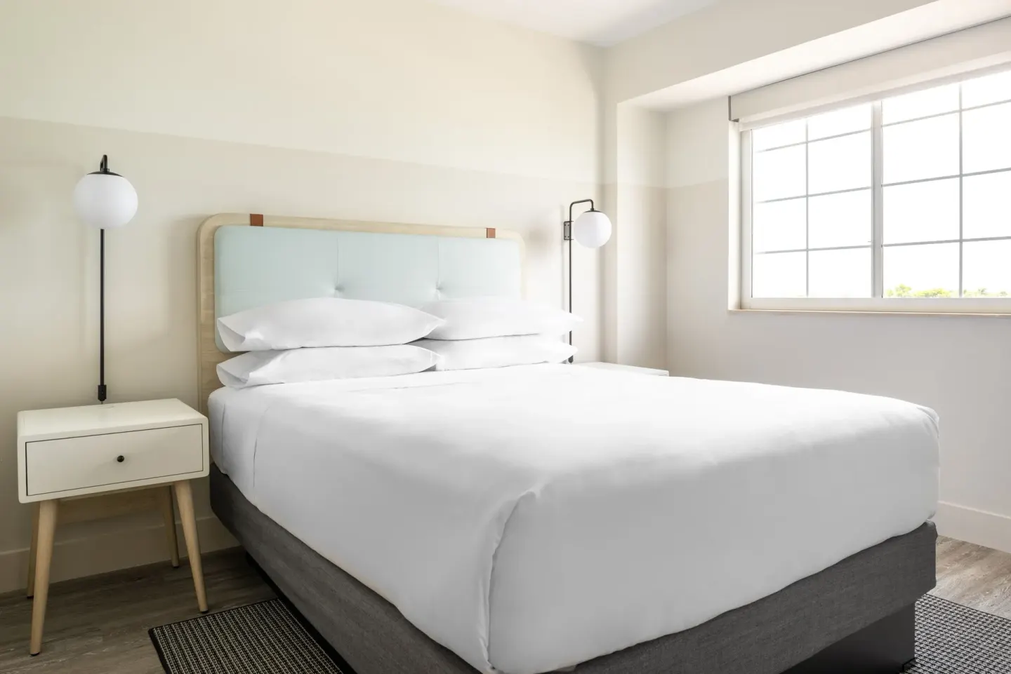 Standard room king bed and window at Hampton by Hilton Grand Cayman Seven Mile Beach.