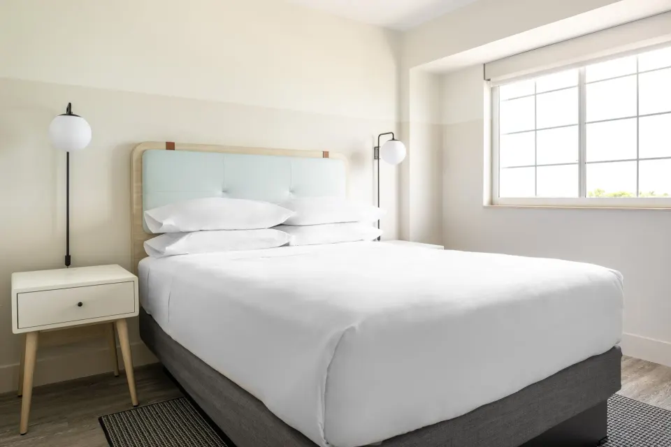 Standard room king bed and window at Hampton by Hilton Grand Cayman Seven Mile Beach.