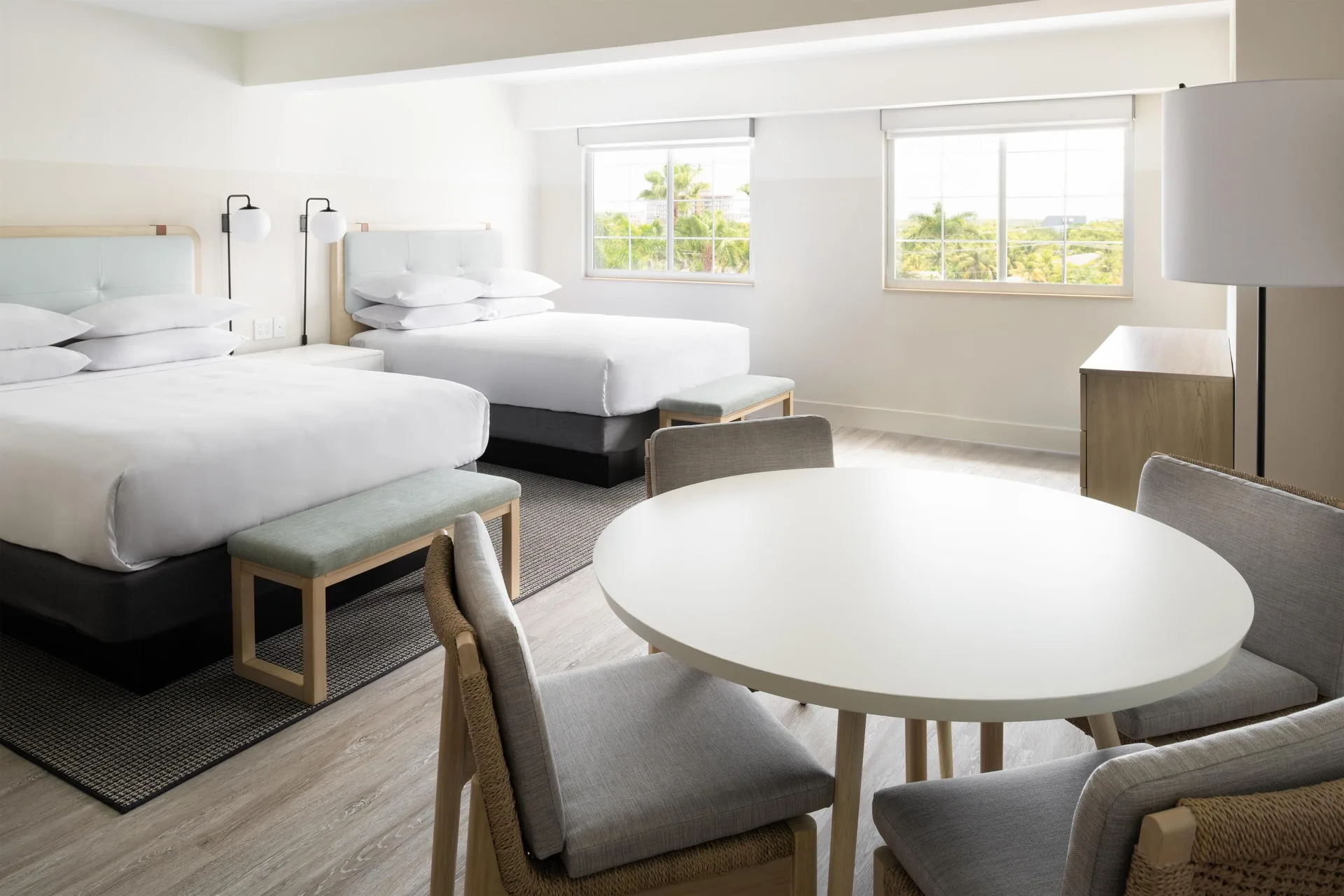 Standard room with two beds and round dining table at Hampton by Hilton Grand Cayman Seven Mile Beach.