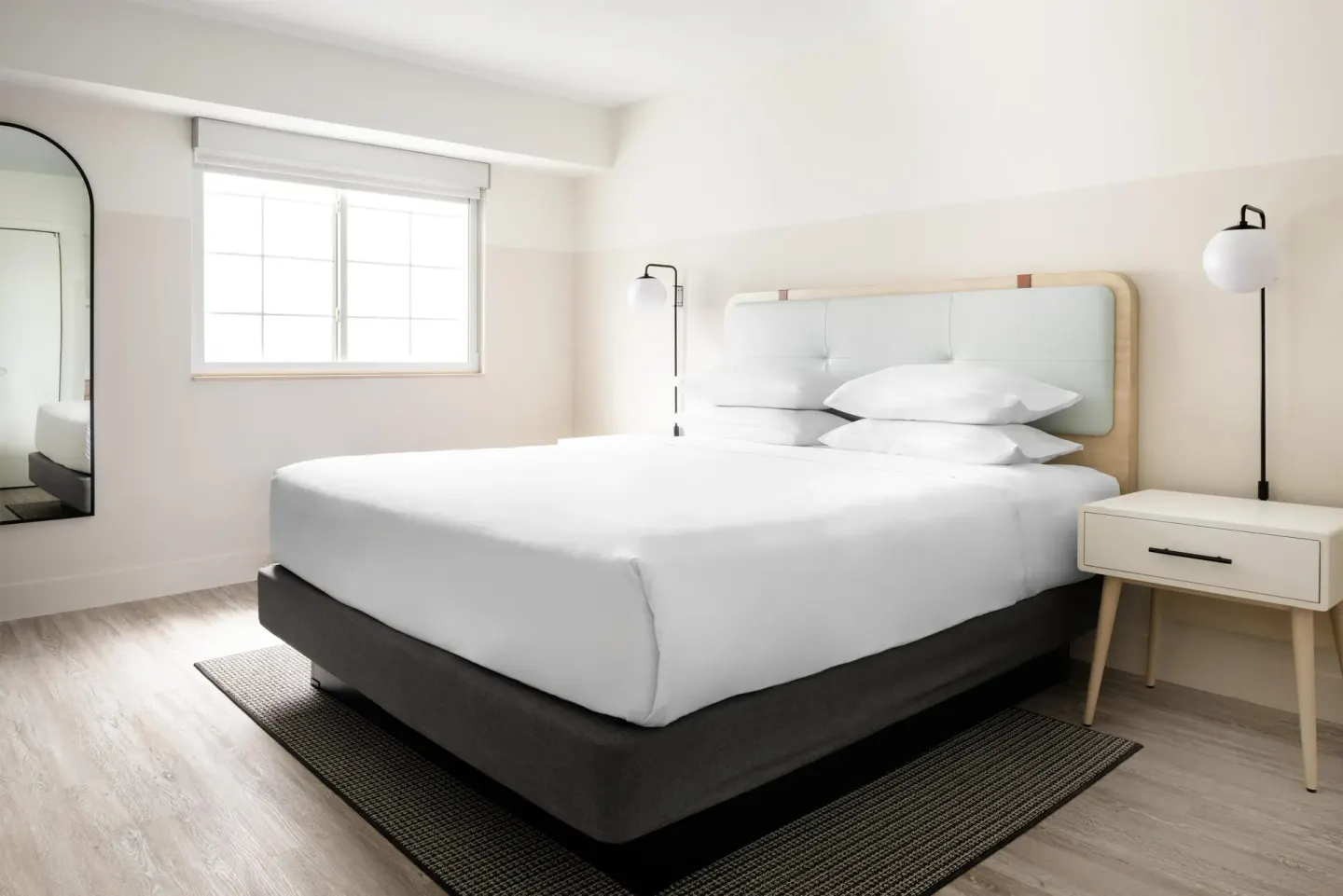 King bed, window, mirror, and nightstand in an accessible studio at Hampton by Hilton Grand Cayman Seven Mile Beach.