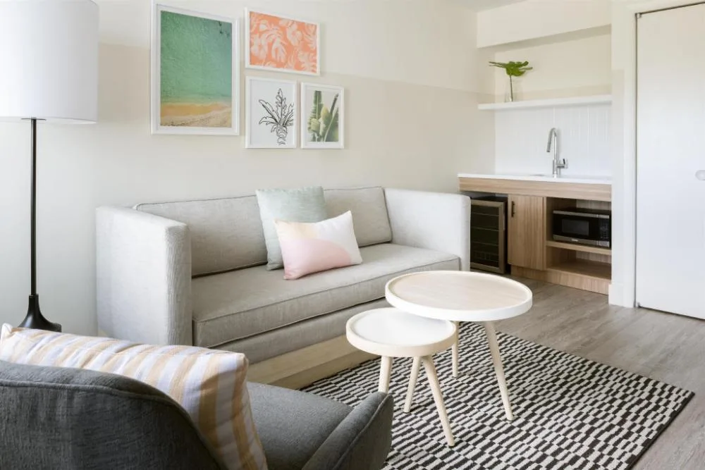 Studio living area with sofa bed and kitchenette at Hampton by Hilton Grand Cayman Seven Mile Beach.