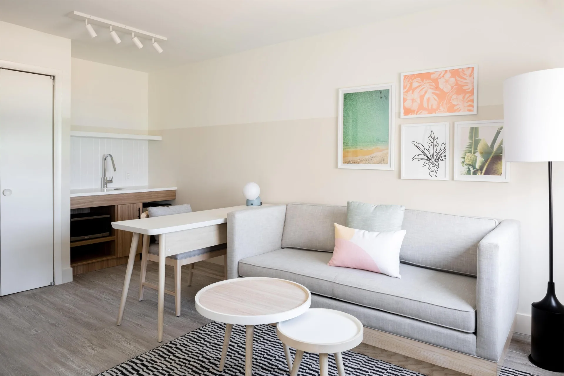 Studio living area with sofa and kitchenette at Hampton by Hilton Grand Cayman Seven Mile Beach.